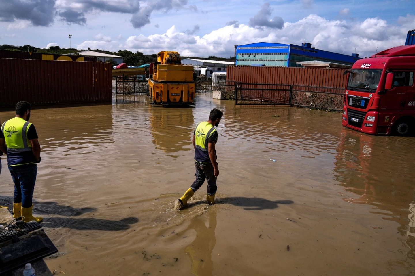Arbeiter laufen nach Überschwemmungen durch schwere Regenfälle durch das Hochwasser.